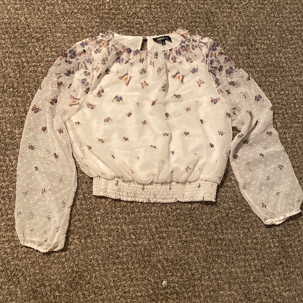 A white blouse with natural colored butterflies